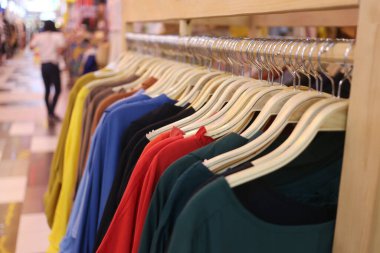 Moda mağazasının çamaşır ipinde asılı renkli kıyafetler..