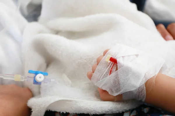 生理食塩水と薬のための子供の腕の上の血管の穿刺のための医療機器 — ストック写真