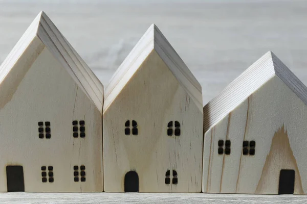 Front of the wooden model house on wooden background.