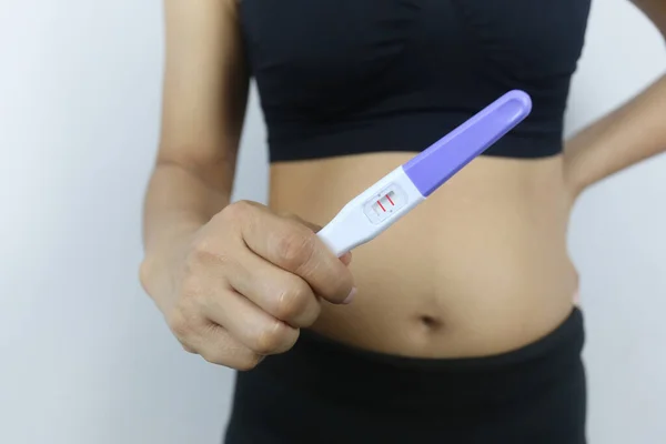 女性の手で妊娠検査ツール テストの結果妊娠を示す 黒のドレスの女性 — ストック写真