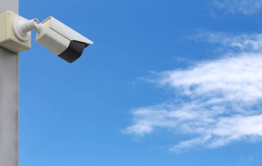 Mavi gökyüzü arkaplanı üzerindeki CCTV aracı, güvenlik sistemleri için ekipman ve tasarım için kopyalama alanına sahip.