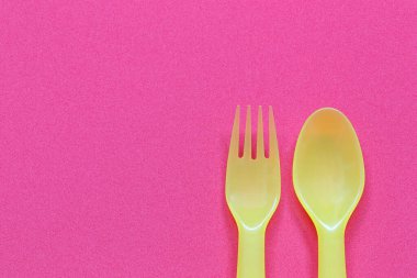 Plastik kaşık ve çatal parlak bir arkaplana yerleştirilir ve çalışmalarınızda tasarım için kopya alanı bulunur.