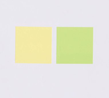 Beyaz kağıt arkaplan üzerine renkli kare kağıt ve sizin için kopyalama alanı var.