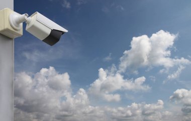 Mavi gökyüzü arkaplanı üzerindeki CCTV aracı, güvenlik sistemleri için ekipman ve tasarım için kopyalama alanına sahip.