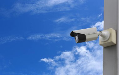 Mavi gökyüzü arkaplanı üzerindeki CCTV aracı, güvenlik sistemleri için ekipman ve tasarım için kopyalama alanına sahip.