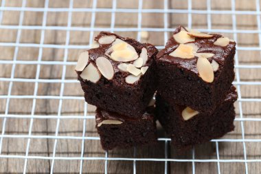 Badem dilimli, ağız sulandıran çikolatalı brownie sergisi soğutma rafında güzelce yerleştirilmiş, herhangi bir tatlı aşığı ya da fırın vitrini için ideal..