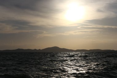 Günbatımı ve gökyüzü alacakaranlığı ile Karadeniz manzarası, Tayland 'ın tropikal kıyılarını akşam adaları ile birlikte görmek.