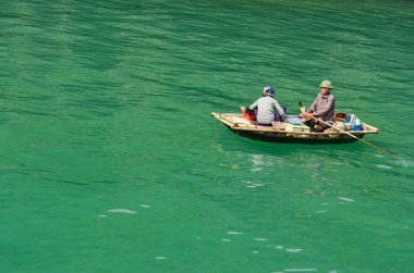 Küçük tekne Ha uzun Bay, Vietnam zümrüt suların bir adam tarafından rowed. Zümrüt suları ve yağmur ormanları tarafından tepesinde kule kalker Adaları binlerce olduğunu. 