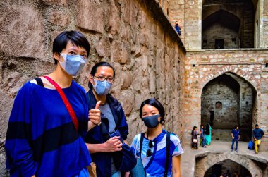 3 Asya turist maskeli Ugrasen ki BAOLI, Delhi, Hindistan, 2018 yaklaşık bir mirası Anıtı ziyaret etti. Delhi son derece kirli bir şehir haline gelmiştir ve hatta yerliler için nefes almak zor