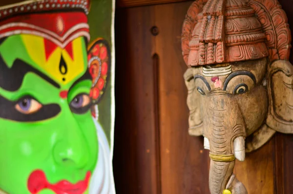 Ganesha face statue and Kathakali mask painting in the background at a Kathakali theater entrance in Fort Kochi, Kerala, India