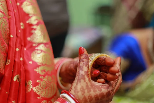 Indian bride wearing wedding traditional red bangles (choora) with henna mehendi hands and getting ready for her wedding ceremony in Delhi, India