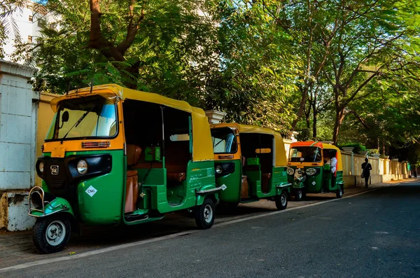 Three auto rickshaws parked on the side of the road waiting for commuters in Delhi, circa 2018. Auto rickshaw is a very popular mode of public transport in Delhi and all over India.