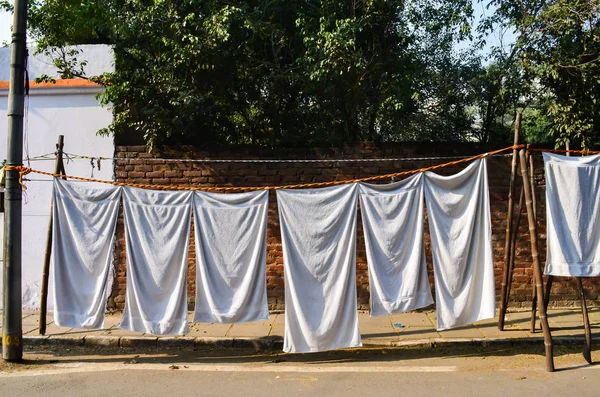 white towels hanging on makeshift tents in streets of central delhi.