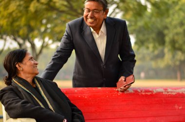 Mutlu görünüyordu gülümseyen ve birbirine açık parkta bakarak üst düzey Hint adam ve kadın çift emekli