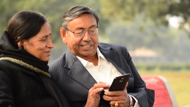 Casal Sênior Lendo Trabalhando Celular Conversando Sorrindo Parque Delhi Índia — Vídeo de Stock