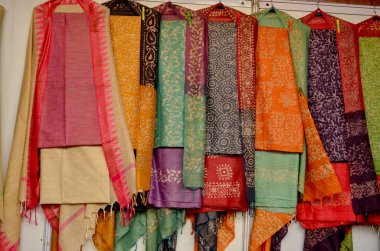 Fancy Indian silk suits hanging on display in a Swadeshi khadi handloom exhibition at Delhi Haat, Delhi, India clipart
