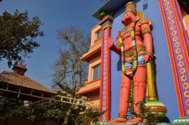 Yan düşük açı görünümü eski büyük kırmızı renkli Hindu tanrısı Hanuman heykeli Delhi'de bir Tapınak binası dışında, Hindistan