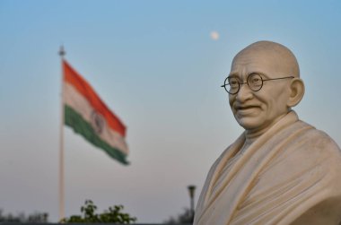 Bust of Gandhi statue with Indian tricolor in the background in Connaught Place, Ahmadabad, Surat, Gandhinagar, Gujarat, Delhi, India. Mahatma Gandhi is the Father of the Nation. clipart