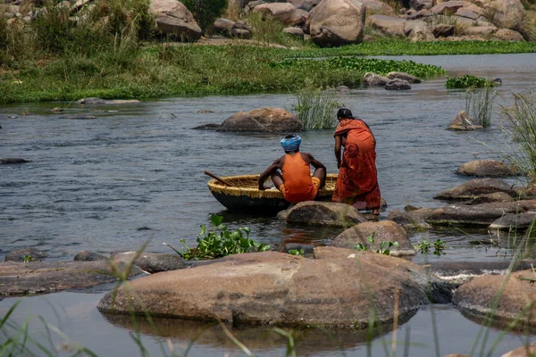 Balıkçı ve eşi Tungabhadra Nehri, Hampi, Karnataka, Hindistan yeni yolcular için dongi olarak bilinen kâhin tekne hazırlanıyor