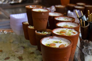 Seçme sokak gıda Lassi veya tatlı ayran / Badaam badem süt tutulur bir tatlı satıcılar yol yan dükkanında toprak bardaklar içinde Kalakand ile arka planda Chandni Chowk'tan, eski Delhi, Hindistan. 
