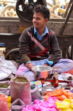 holi Festivali için renkleri satan bir dükkan sahibi portresi