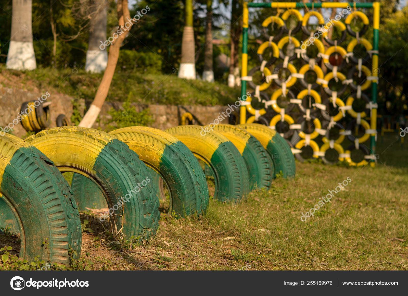 Painted Tires In Green And Yellow Color Placed In A Line And