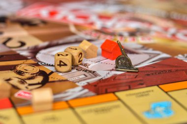 wooden dice and game pieces on board game background out of focus