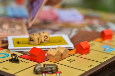 wooden houses of board game with dice in the background