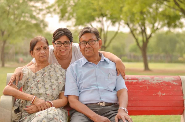 Delhi, Hindistan'da bir parkta poz annesi ve babası ile genç bir Hintli kadının aile portresi