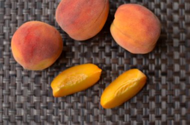 Şeftali yarım ve daha küçük dilimler halinde bir masa mat süslenmiş kesilmiş