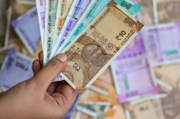 一张10 100 200 500和2000卢比的全新彩色印度纸币的特写 在货币化后随手拿着许多纸币在背景中流通 — 图库照片