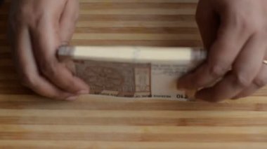 Eller ahşap bir tahta arka plan karşı yeni kahverengi Rs 10 Hint Rupisi Para notları sayma