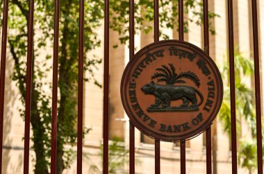 RBI logo on the closed iron gate of Reserve Bank of India (RBI) building at Patel Chowk, Connaught Place with the office building in the background in Delhi, India clipart