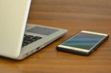 Ahşap bir masa üzerinde arkadan bir ofis kurulumu qwerty klavye ve akıllı telefon soyut görünümü