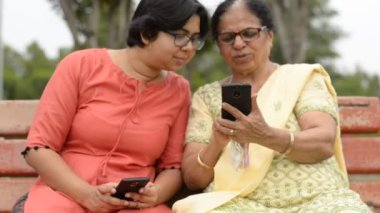 women reading from the phone and laughing