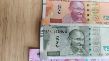 10, 20, 50, mor 100, 200, 500 ve pembe 2000 rupi 'lik yepyeni Hint para birimi banknotlarının kapanışı ve ahşap arka plana karşı yapılan gösteriden sonra sirkülasyon halinde