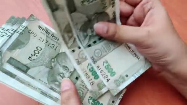 手拿着新的500卢比印度卢比钞票 背景是木制假币 — 图库视频影像