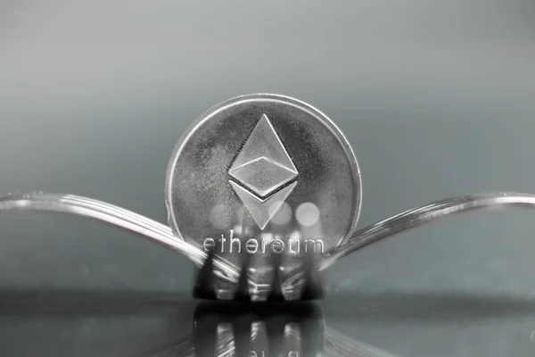 Ethereum cryptocurreny mince mezi vidlice s odraz, pevné vidlice — Stock fotografie