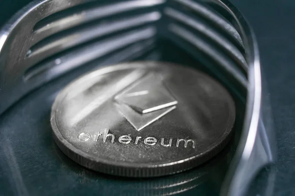 Ethereum cryptocurreny coin placed between forks with reflection, hard fork — Stock Photo, Image