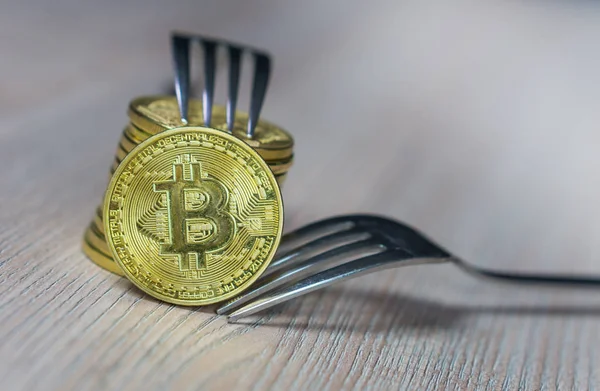 Bitcoin bekommt neue Festgabel Wechselgeld, physische goldene Kryptowährung Münze mit Gabel, Blockchain-Konzept — Stockfoto