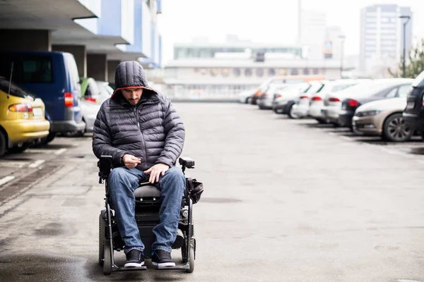 Jeune, adulte en fauteuil roulant sur un parking avec espace de copie — Photo