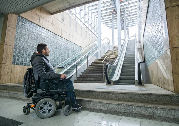 Vista trasera de un hombre discapacitado en silla de ruedas delante de la escalera mecánica y escalera con espacio para copiar — Foto de Stock