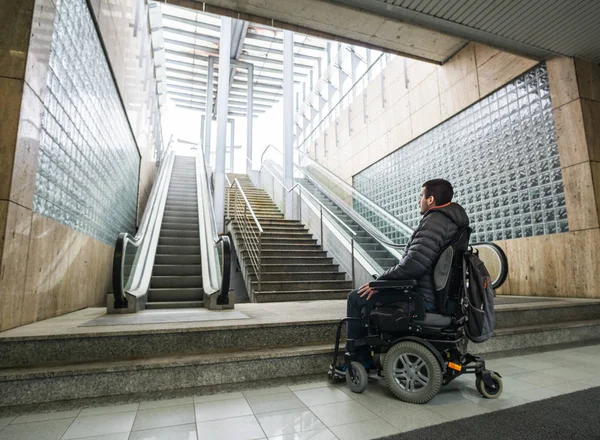 背面ビューの A 障害男の車椅子の前にエスカレーターとコピー スペースと階段 — ストック写真