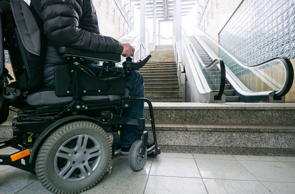 Photo rapprochée de l'homme en fauteuil roulant devant les escaliers roulants et l'escalier avec espace de copie — Photo