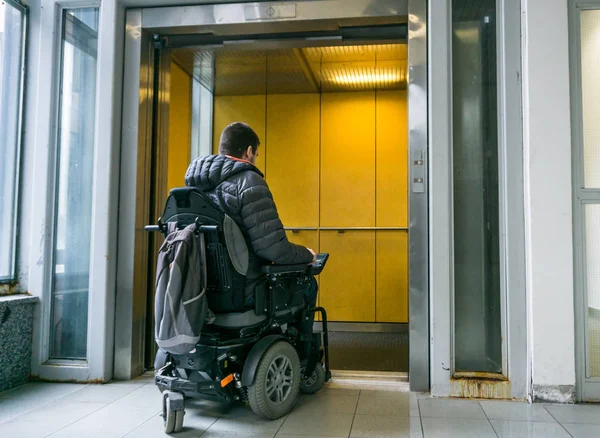 Чоловік з інвалідністю на інвалідному візку їде в ліфті — стокове фото