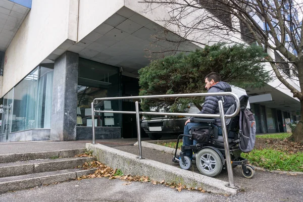 Hombre en silla de ruedas usando una rampa al lado de las escaleras —  Fotos de Stock