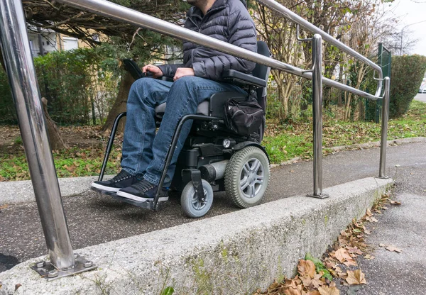 Homme en fauteuil roulant utilisant une rampe à côté des escaliers — Photo