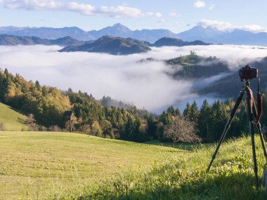 Fotoğraf çekim güzel gündoğumu peyzaj Saint Thomas Kilisesi Slovenya sabah sisin içinde tepenin üzerinde bir tripod üzerinde kamera