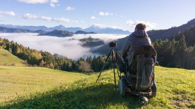 adam tekerlekli sandalye Sisli sabah güzel manzara fotoğrafını çekmek St. Thomas Slovenya