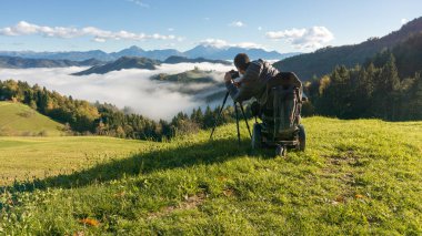 adam tekerlekli sandalye Sisli sabah güzel manzara fotoğrafını çekmek St. Thomas Slovenya